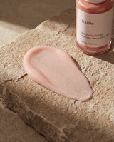 RAIDé Recovery Serum och rosa serumtextur på varm sten